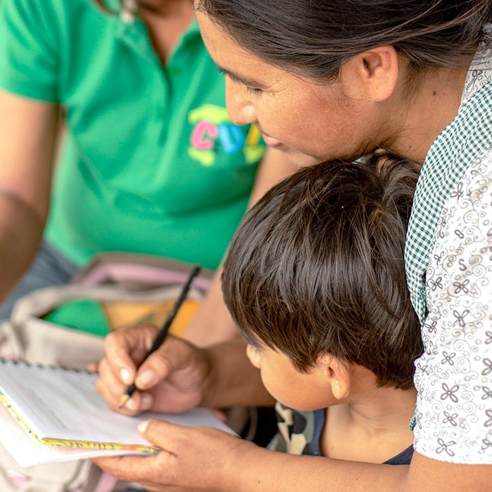 볼리비아 엄마 아니제타(가 아이와 함께 글을 배우고 있다.