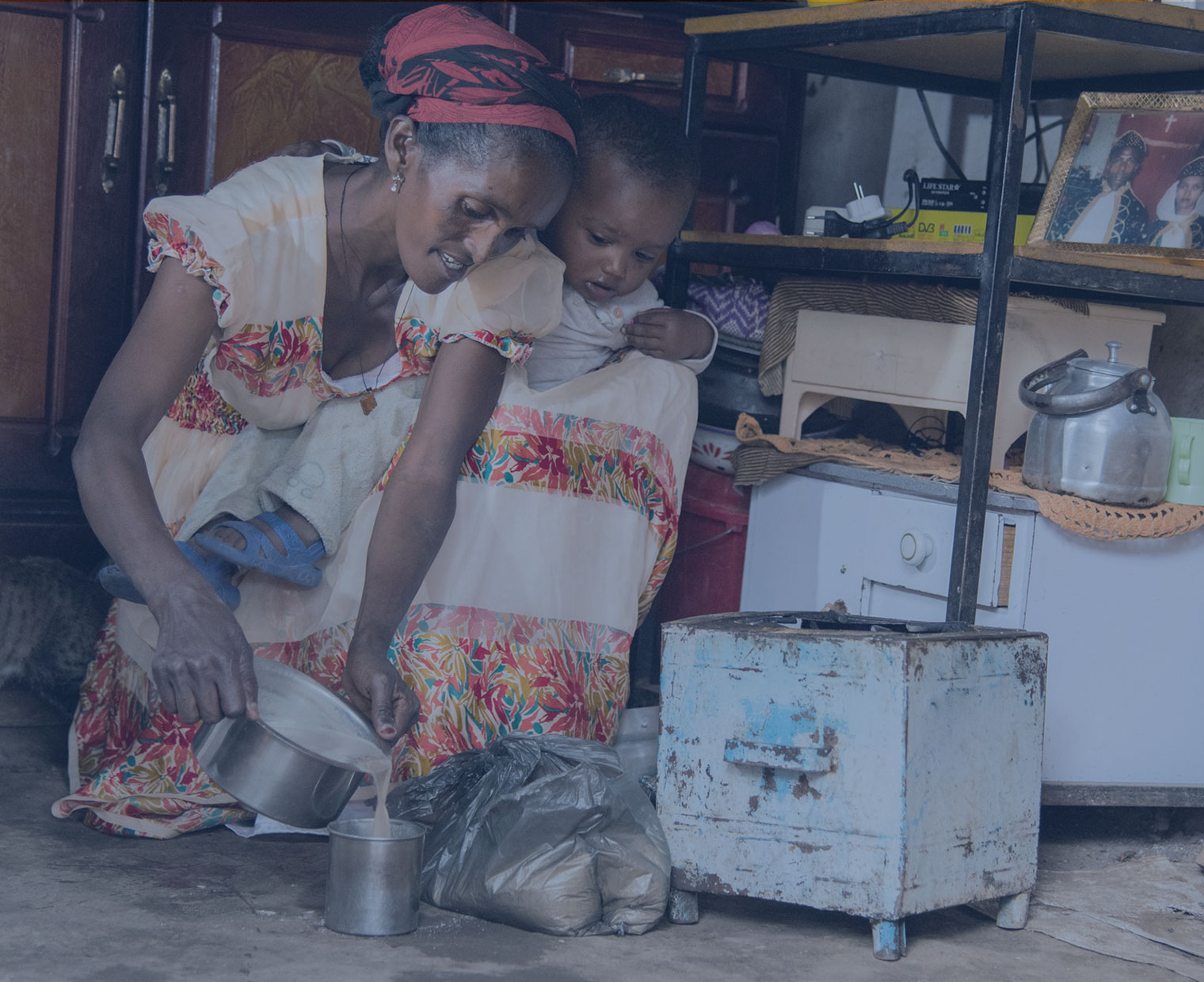 에티오피아 엄마 에브레헷이 아이를 엎고 음식을 만들 고 있다.